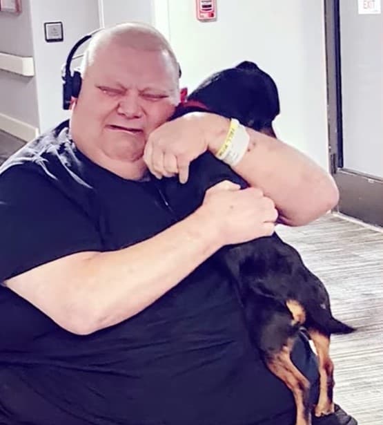 a man hugs his dog and cries