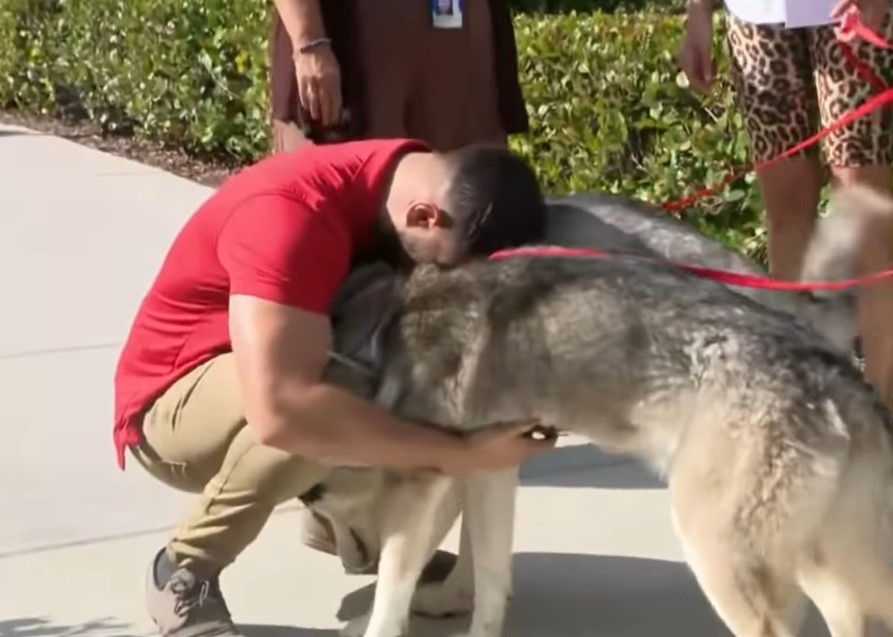 a man hugs his dog on the street