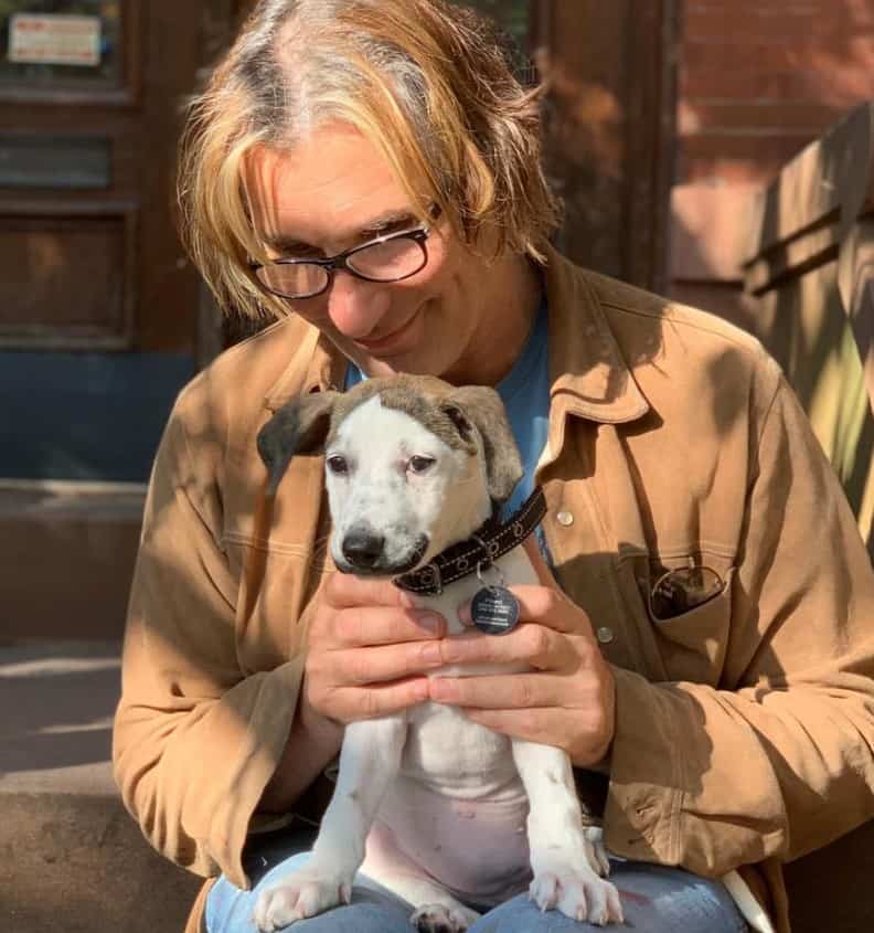 a man is holding his cute mustache dog