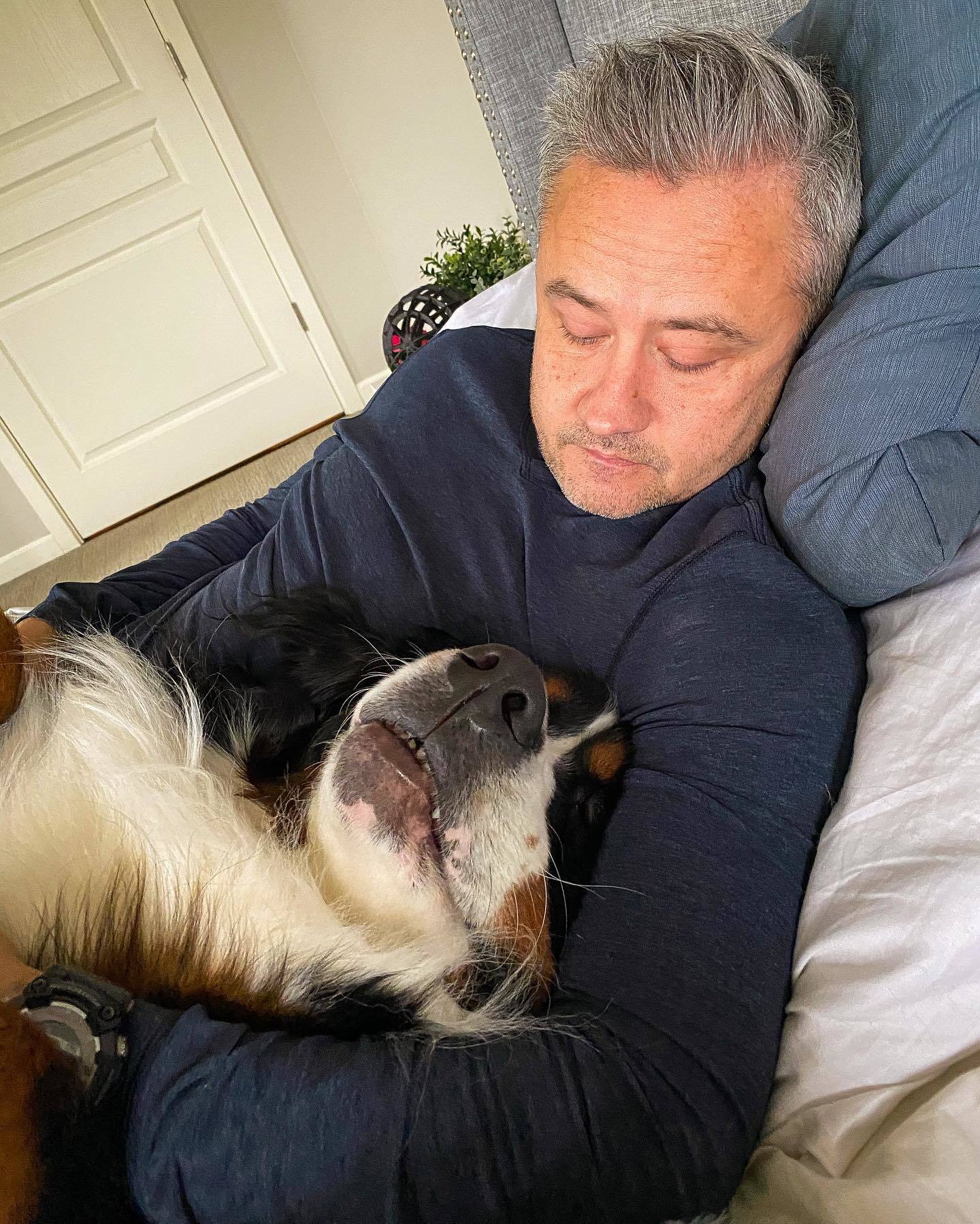 a man laying with bernese