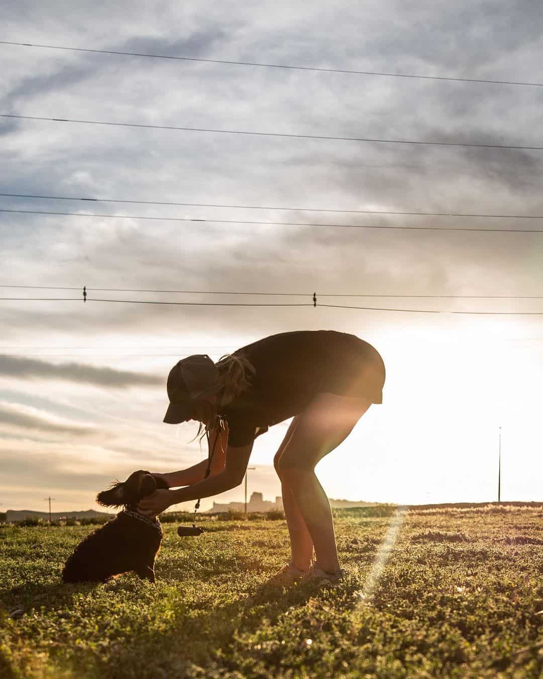 a woman caresses a Boykin Spaniel