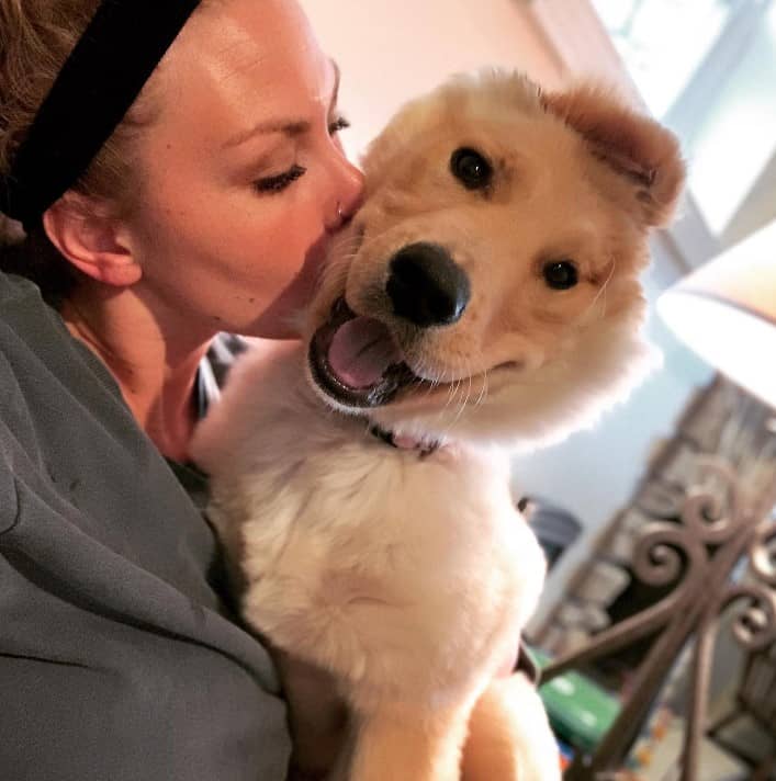 a woman kisses a unicorn puppy