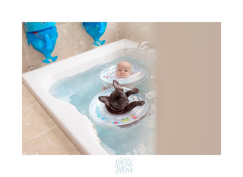 baby and dog floating in a bathtube