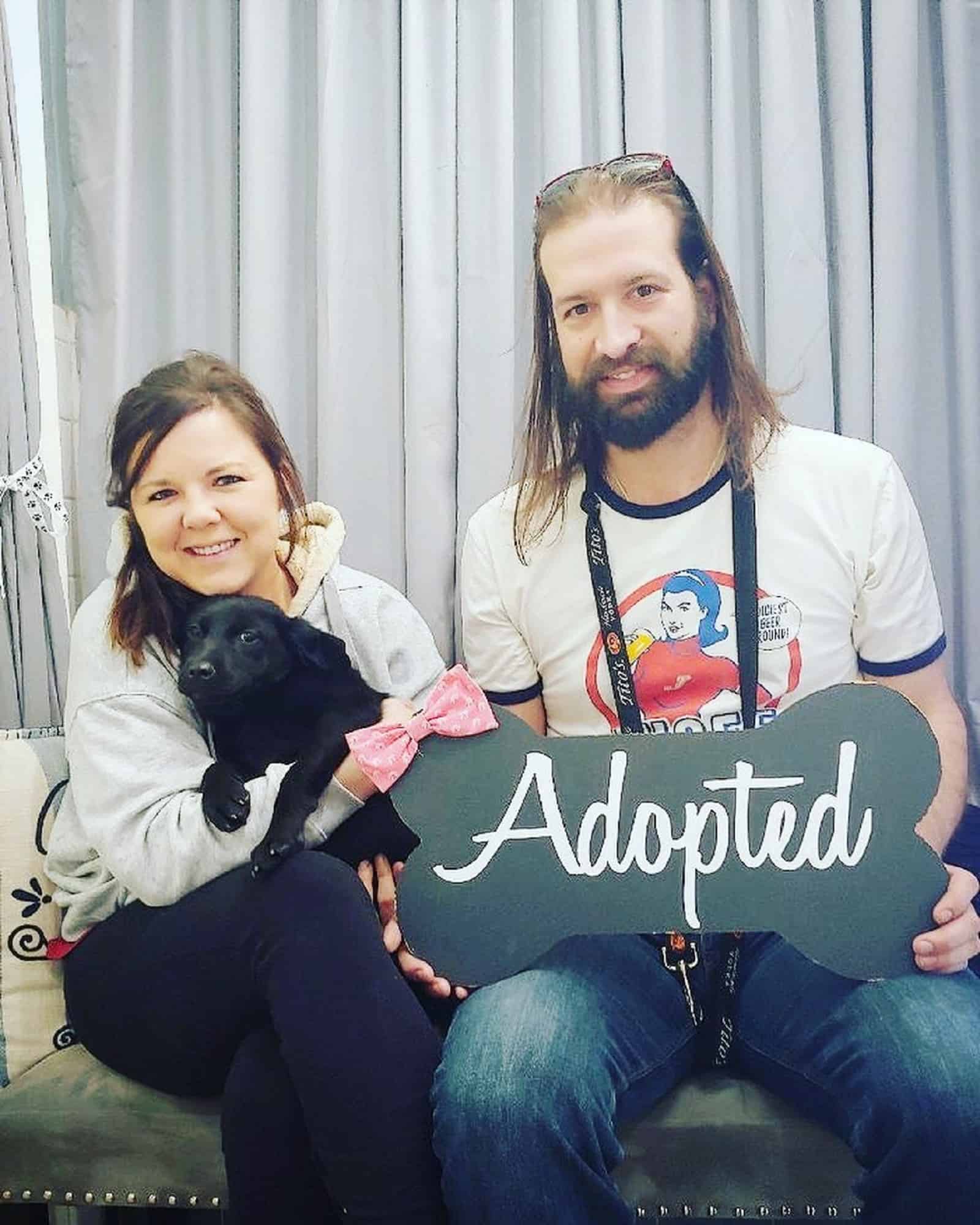 black puppy with his new family on the couch