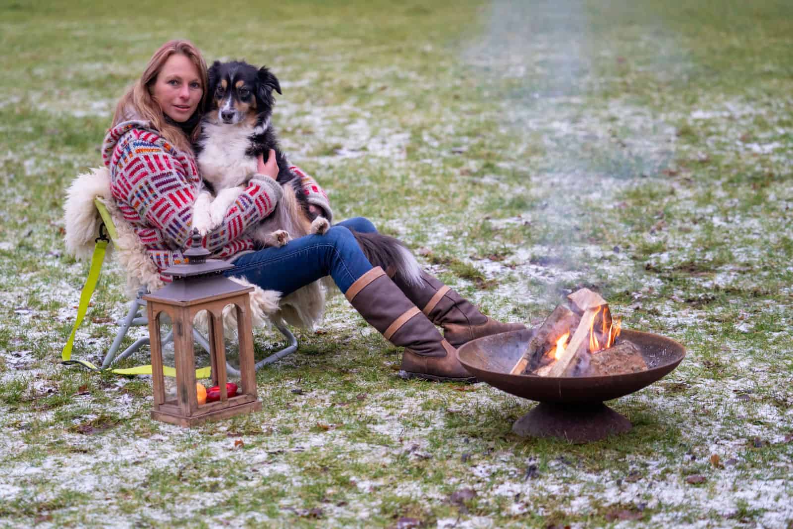 Blonde woman with her Australian Shepherd dog on her lap.