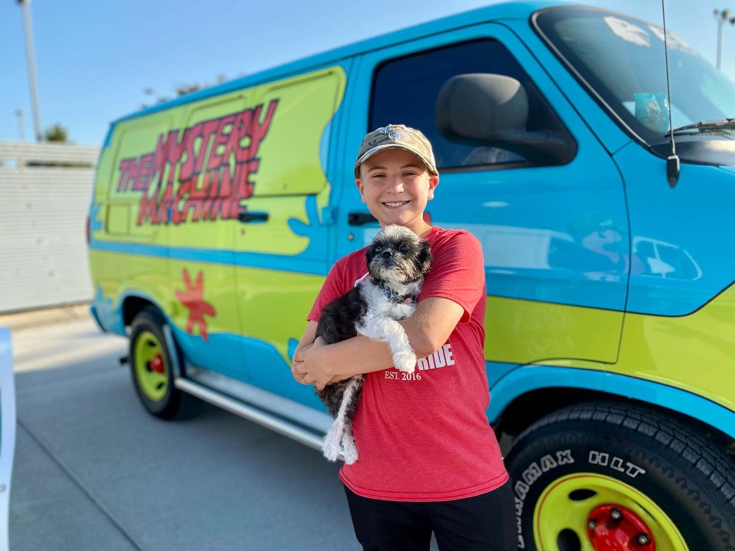 boy holding a dog and smiling