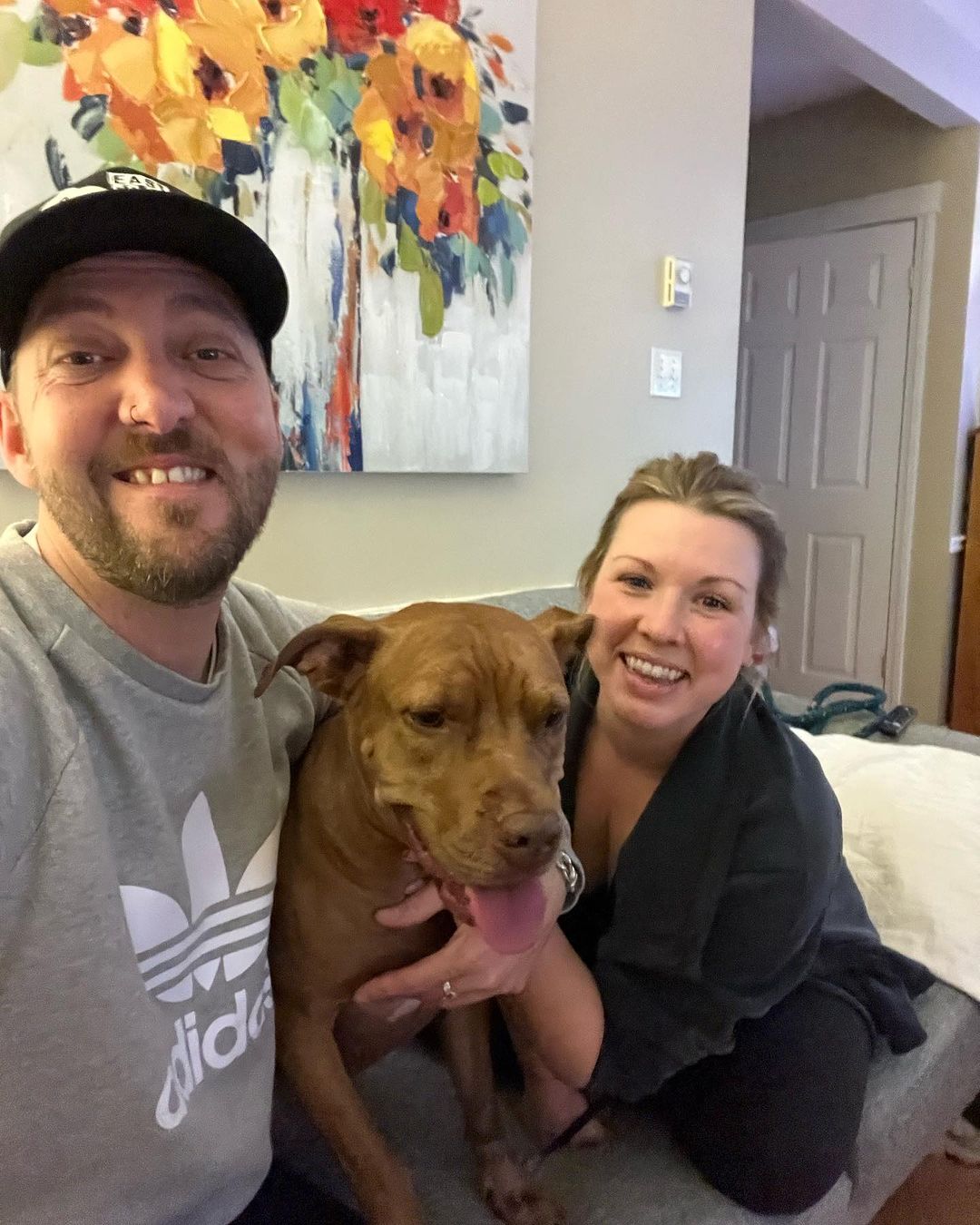 Couple and dog sitting on couch