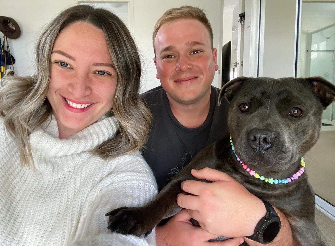 couple holding a dog