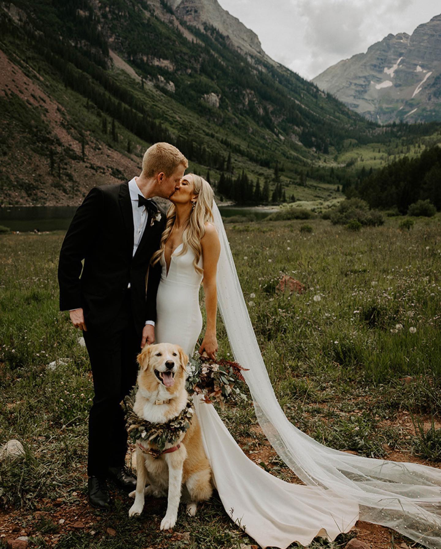 couple kissing and dog sitting by their side