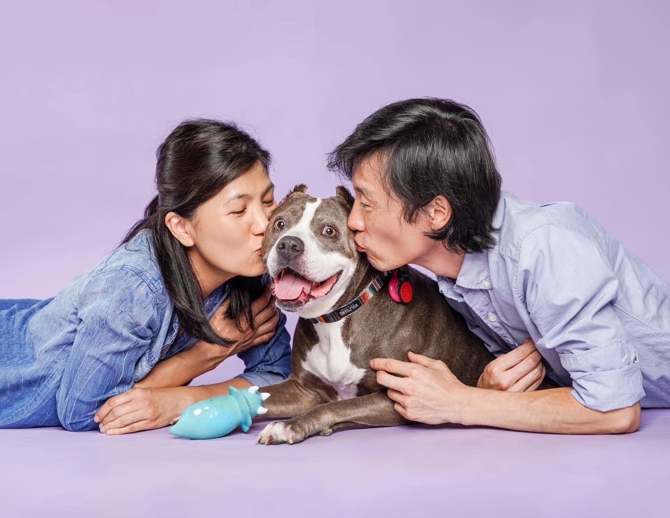 couple kissing their dog