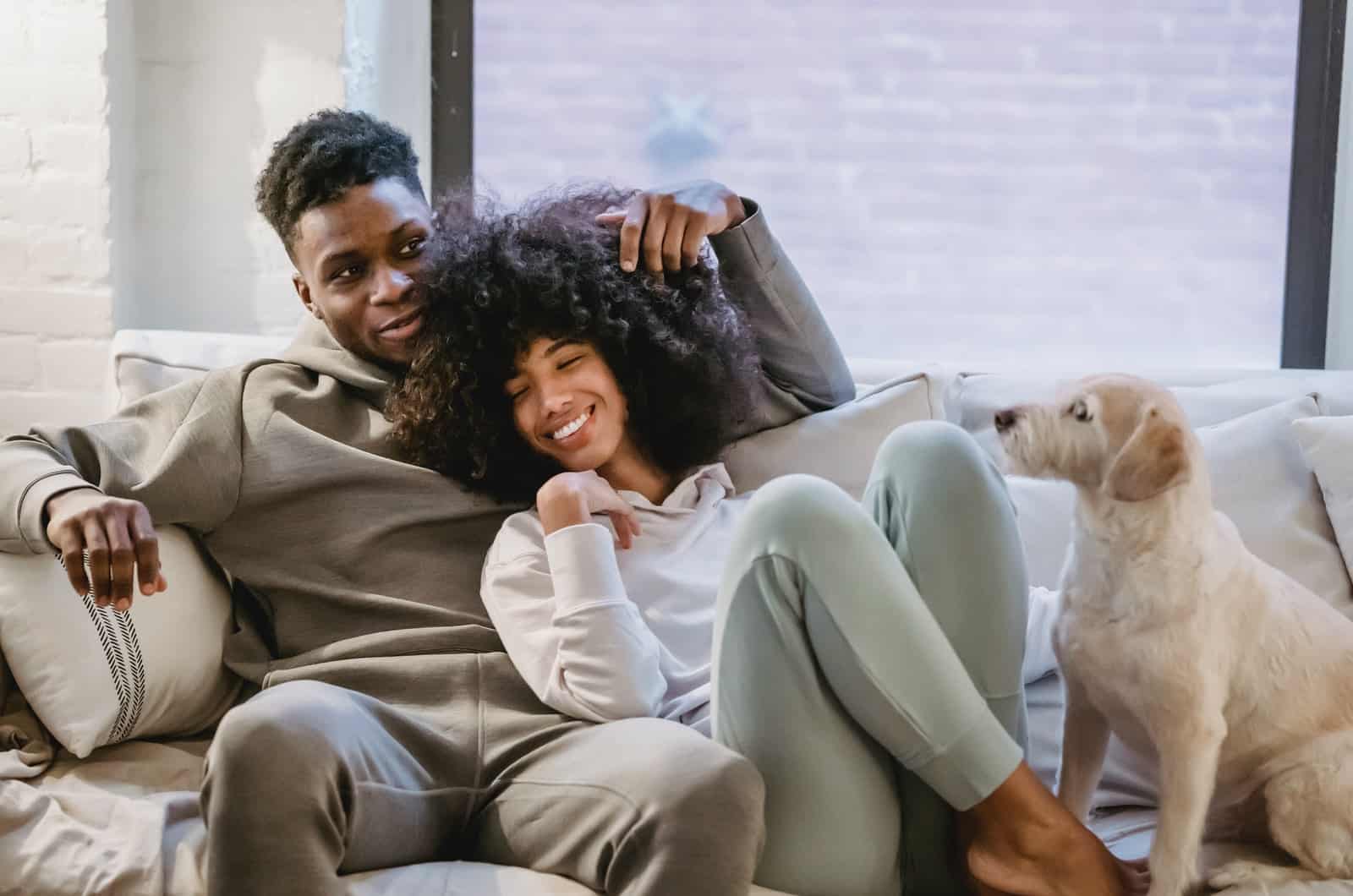 couple lying on couch with dog