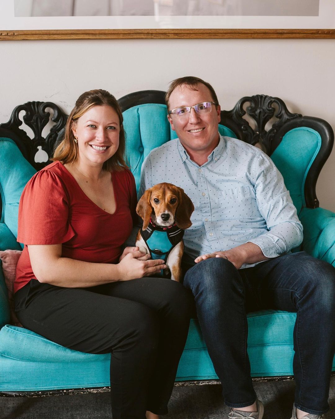 couple sitting on a sofa with beagle