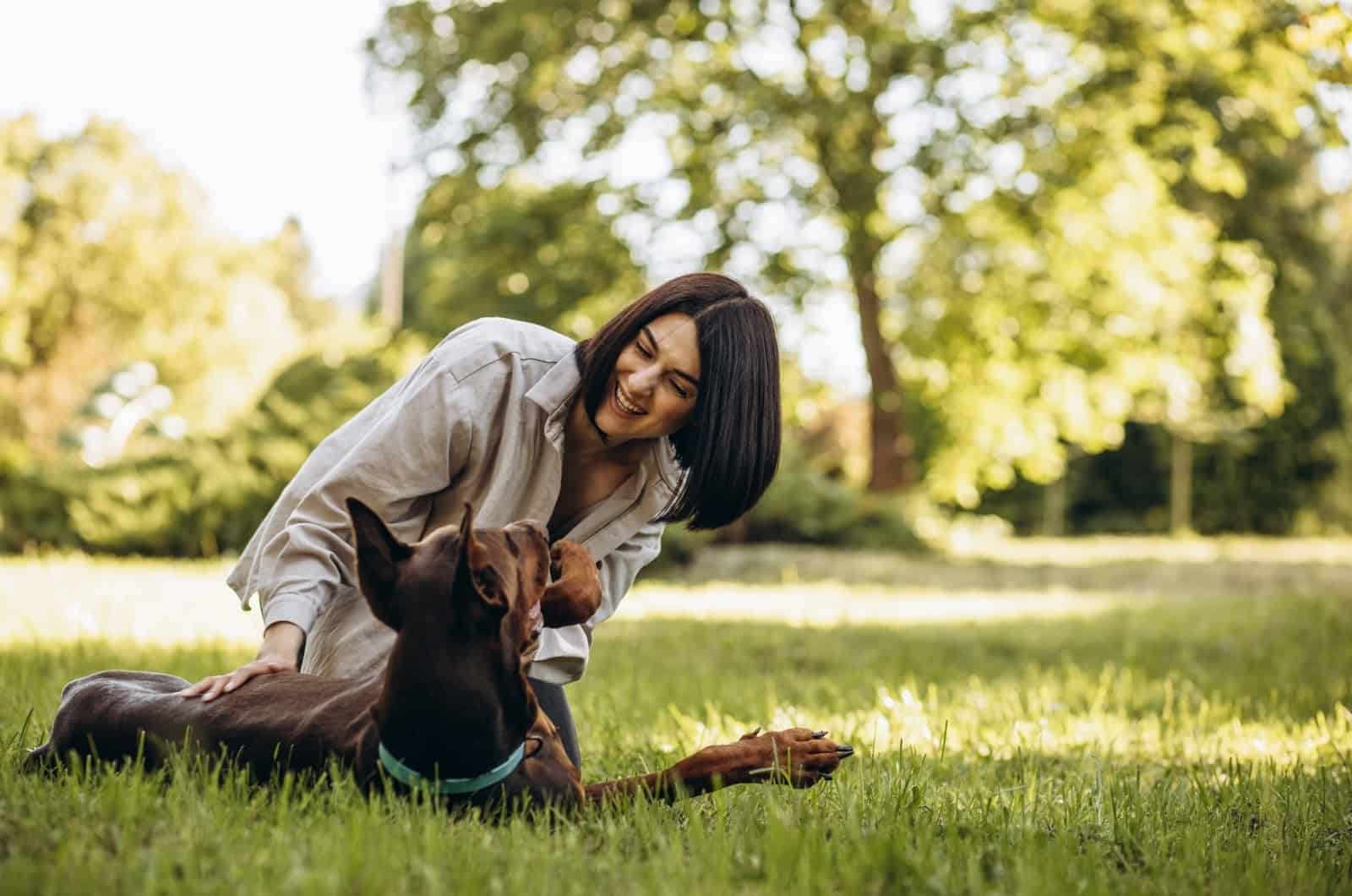 Doberman playing with girl outside