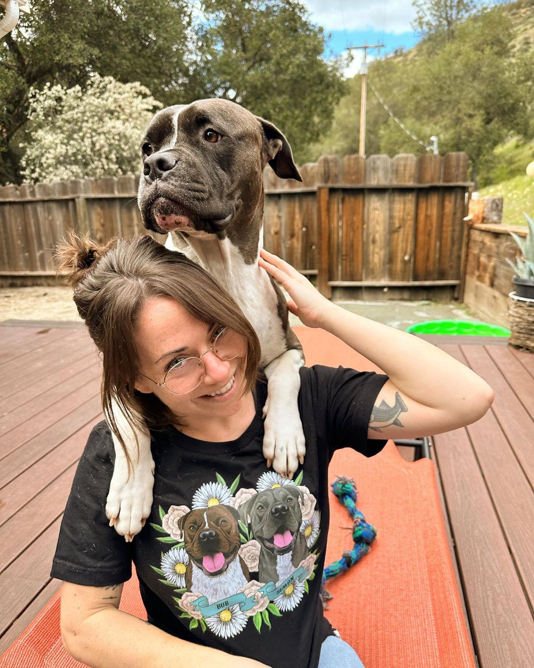 dog leaning on woman's shoulders