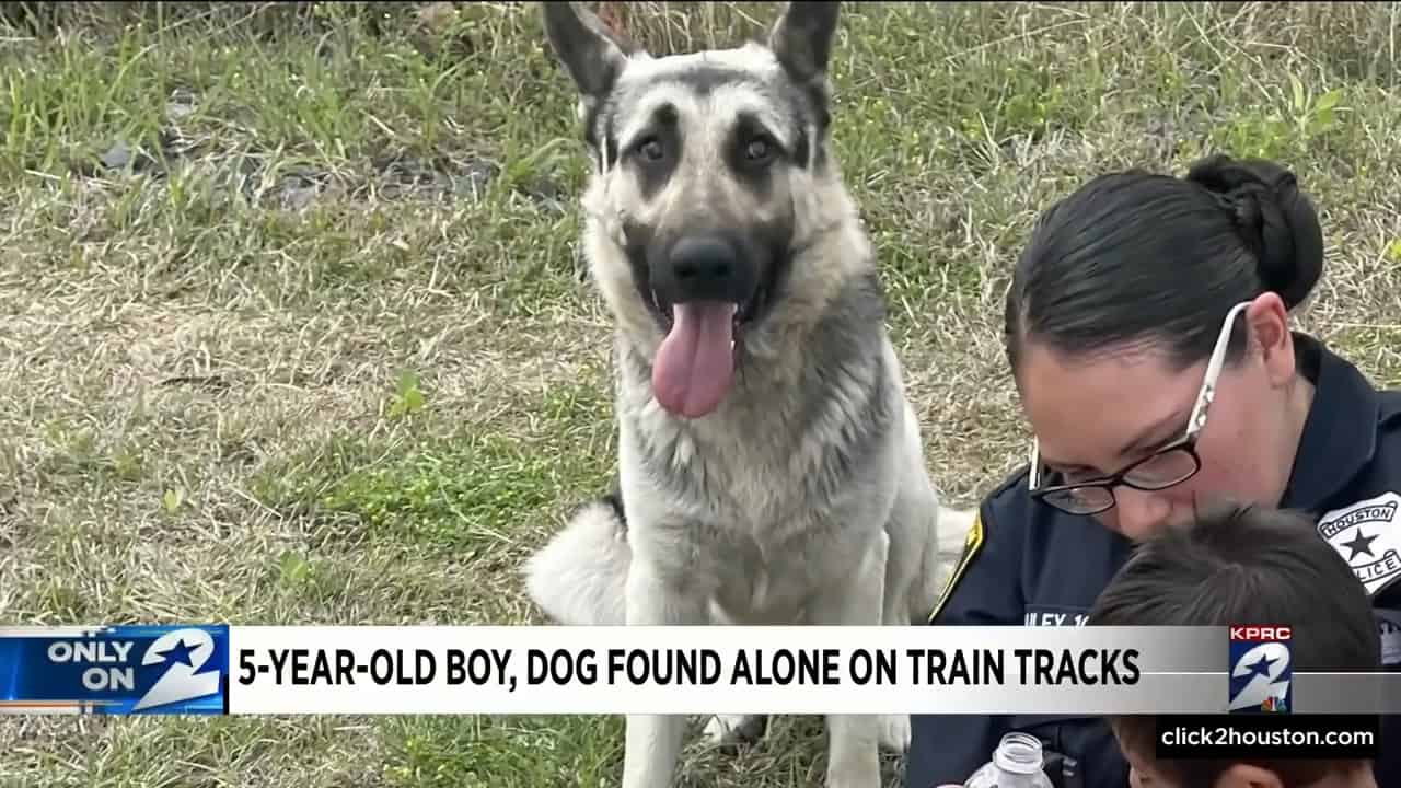 dog sitting next to police woman and a boy