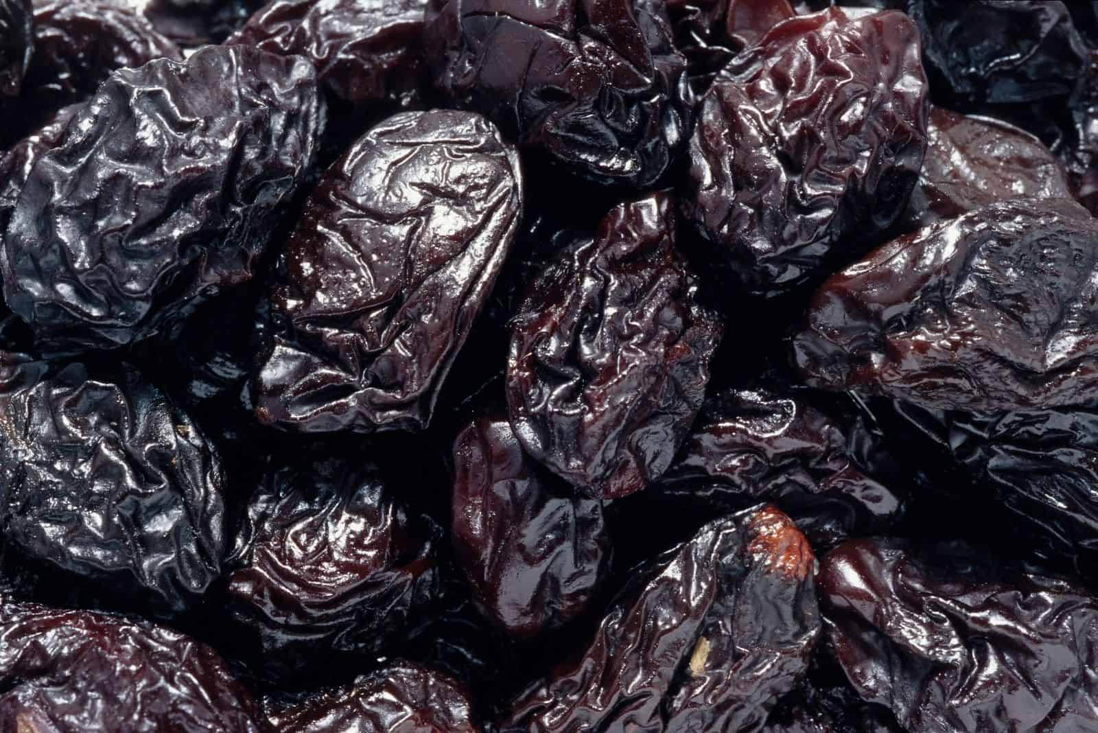 dried black prunes in close up photography