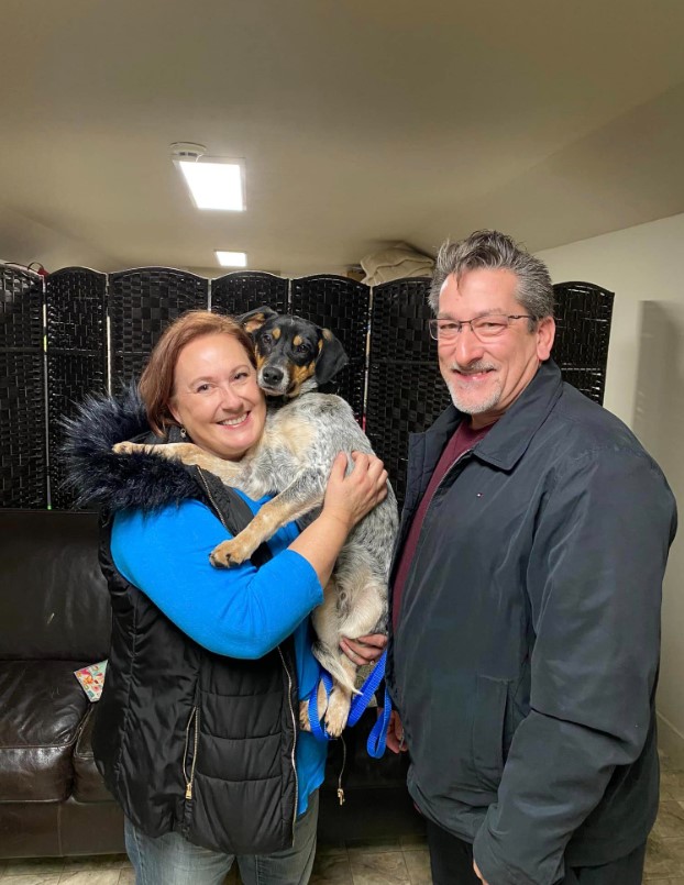 elderly loving couple with a dog in their arms