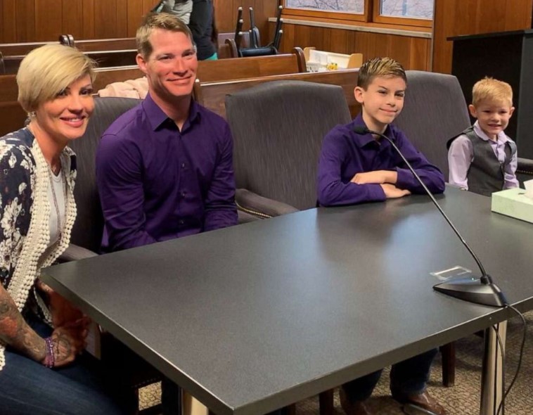 family of four (mom and dad and two boys) sitting at the table