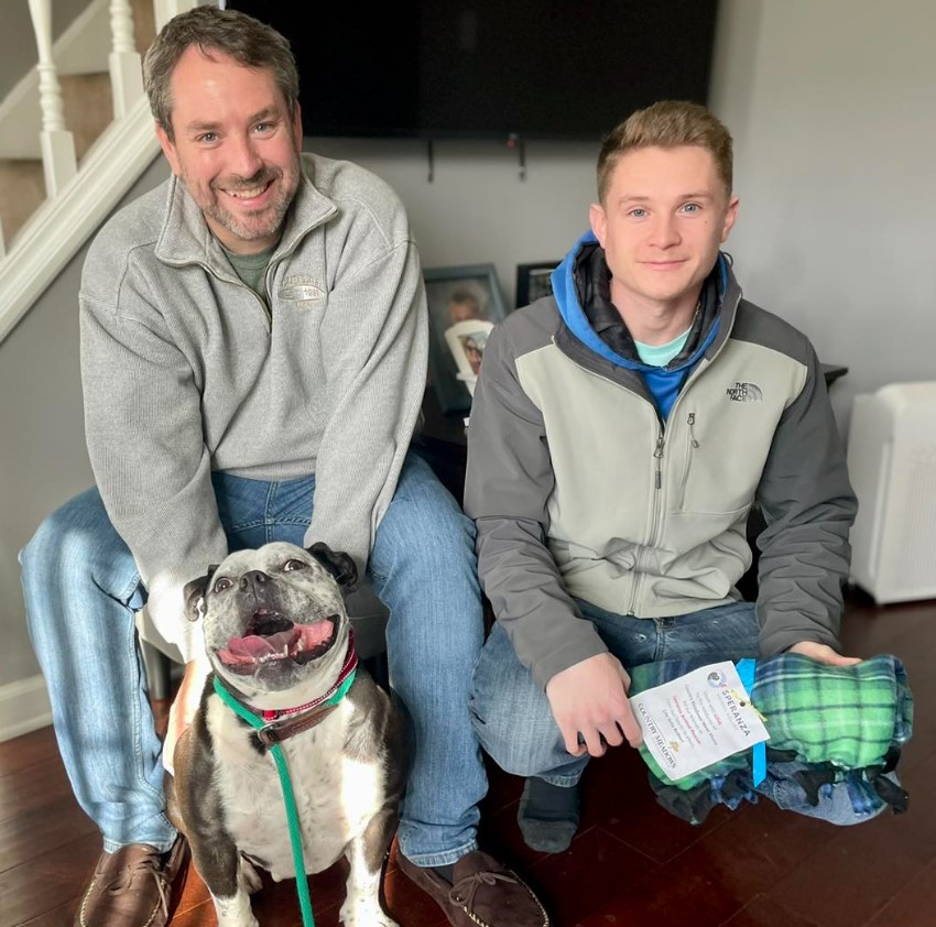 father and son with a smiling dog take a picture