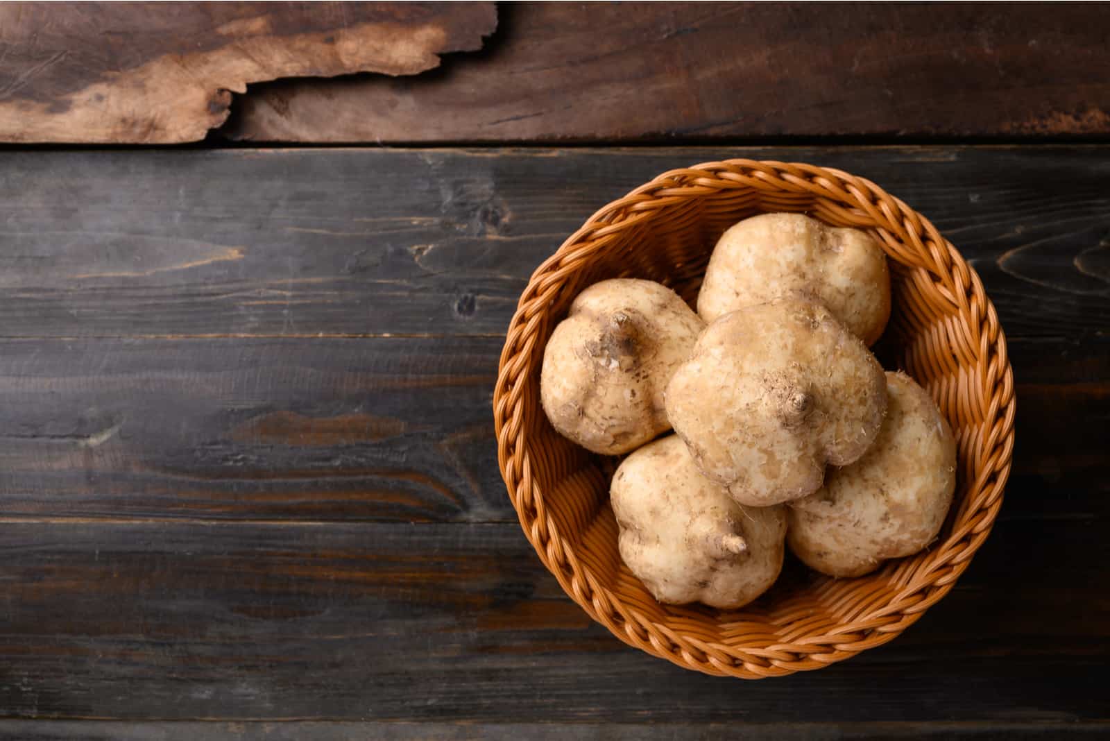 Fresh jicama in a basket on wooden background