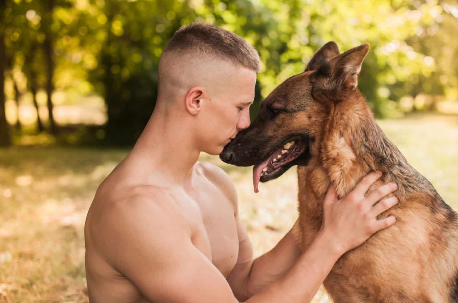 german shepherd dog lying his head on his owner in the park