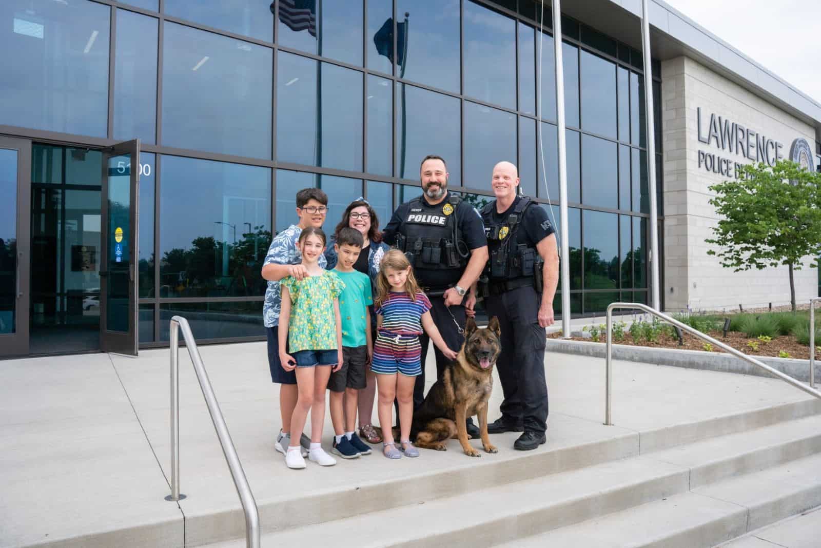 german shepherd dog with his new family and police officers