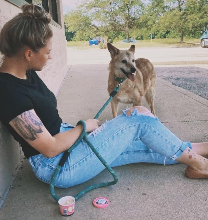 girl holding her dog on a leash