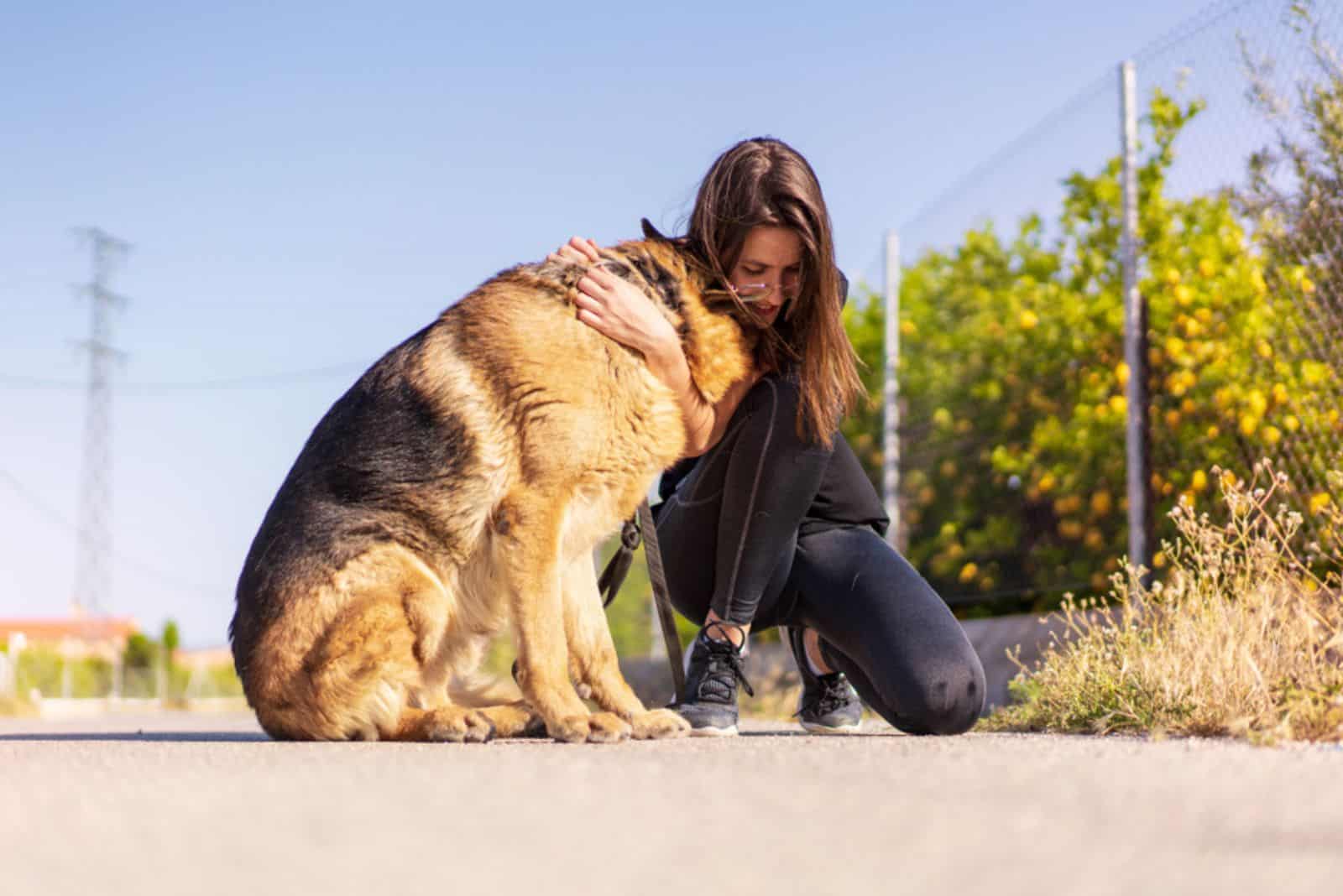 girl hugging german shepherd dog outdoors