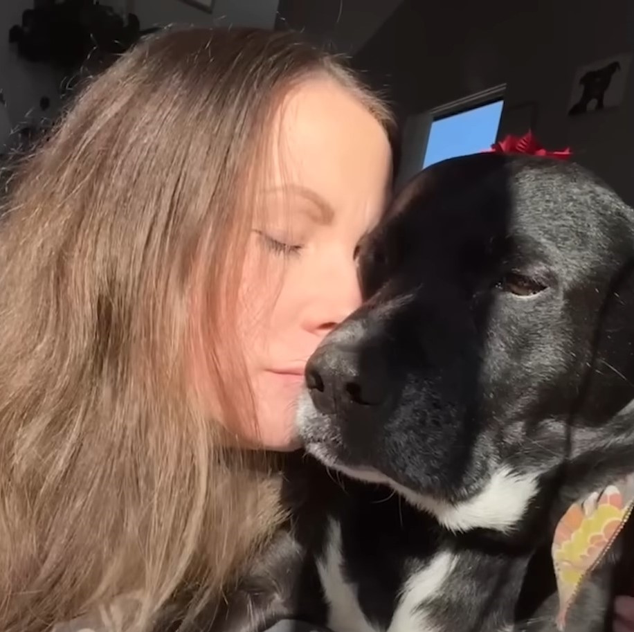 girl hugging her black dog