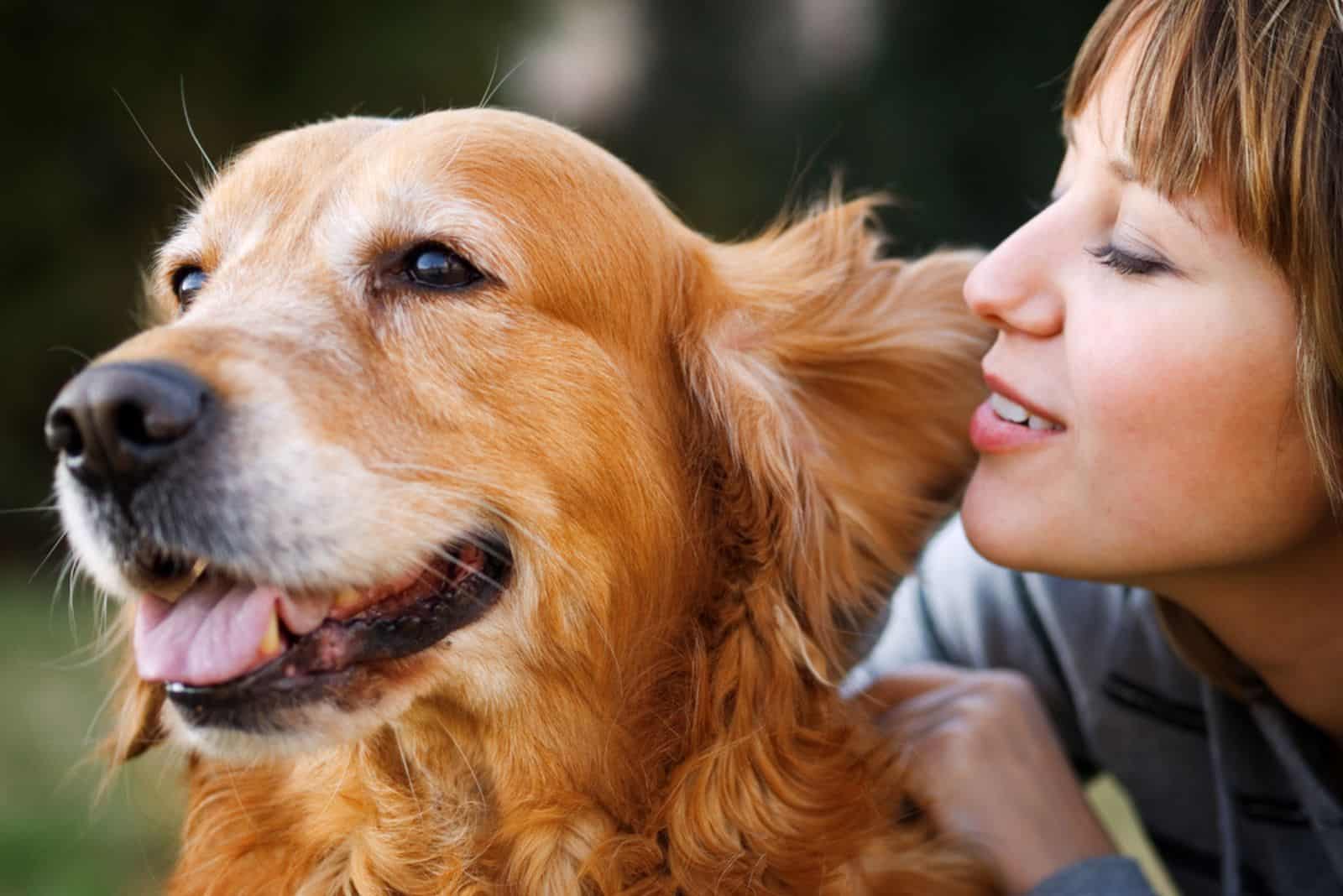 Girl whispering in her dog's ear in the park