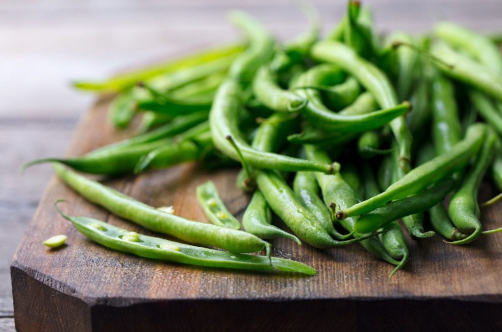 green beans on wooden cutting board