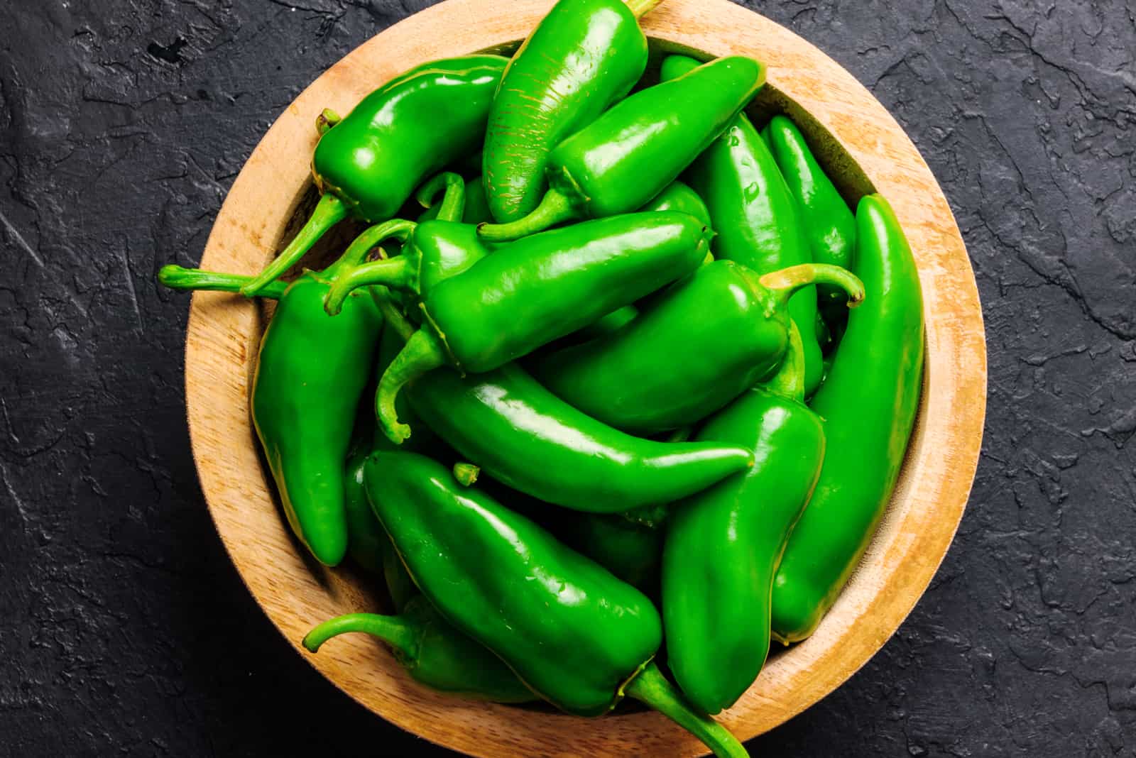 Green jalapeno hot pepper in wooden plate