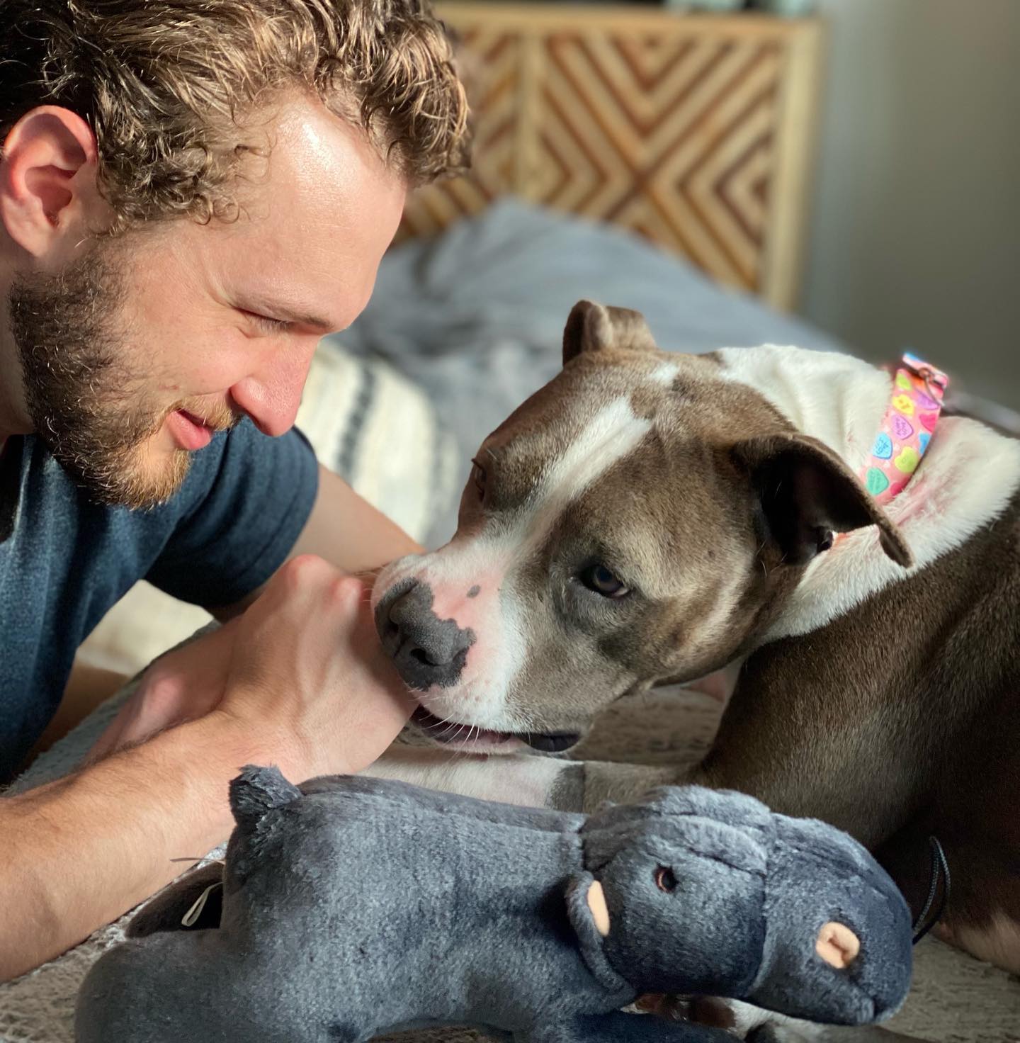 guy with beard playing with dog