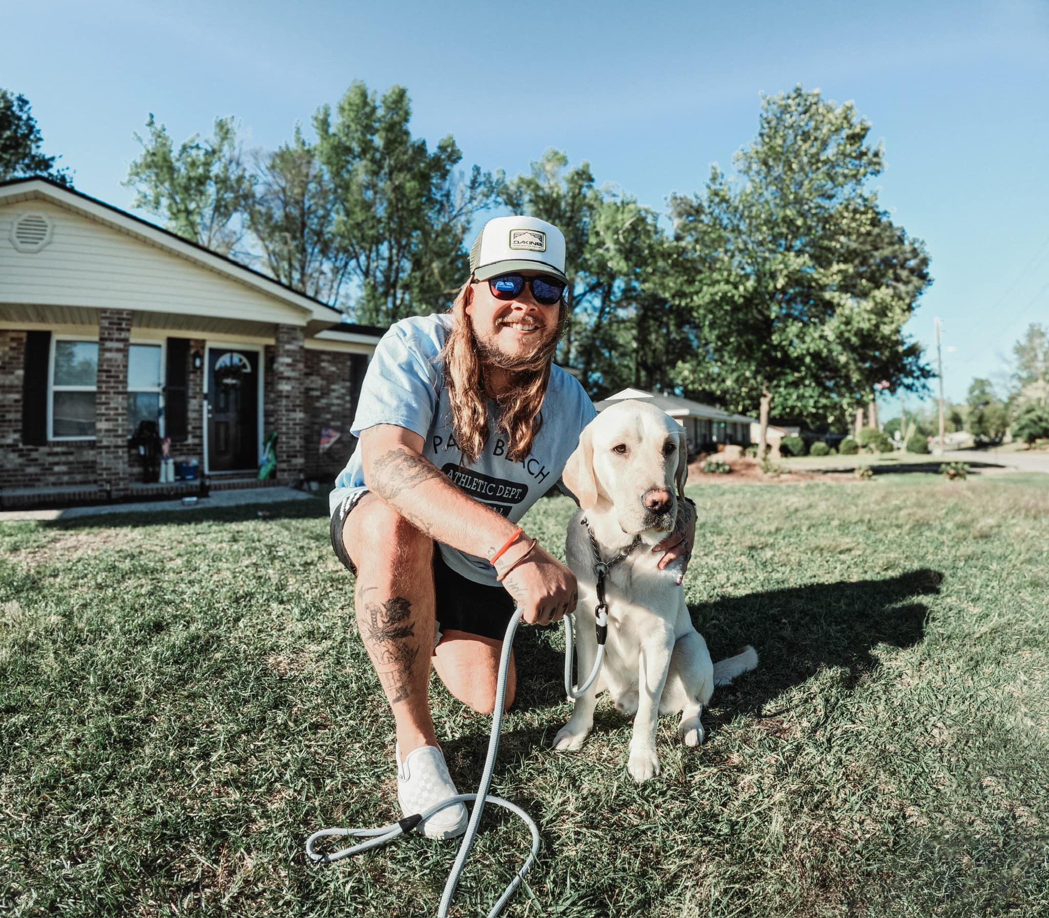 guy with long hair and white dog