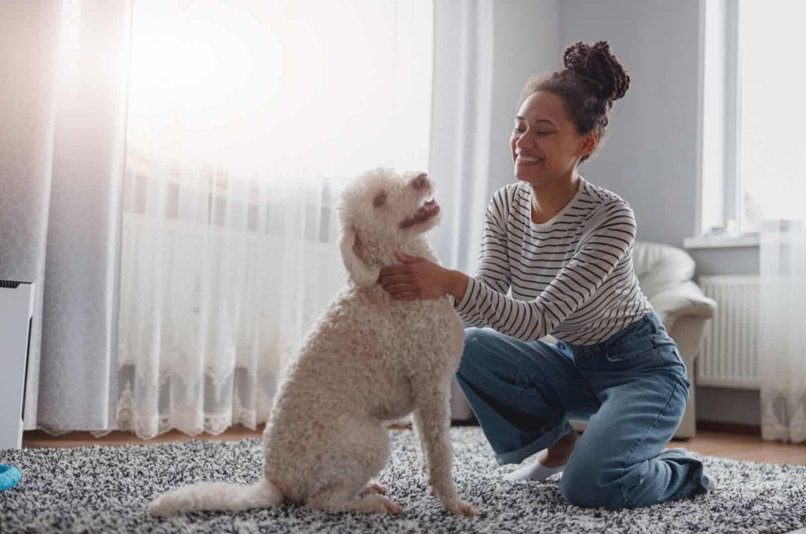 happy woman playing with happy dog on the carpet