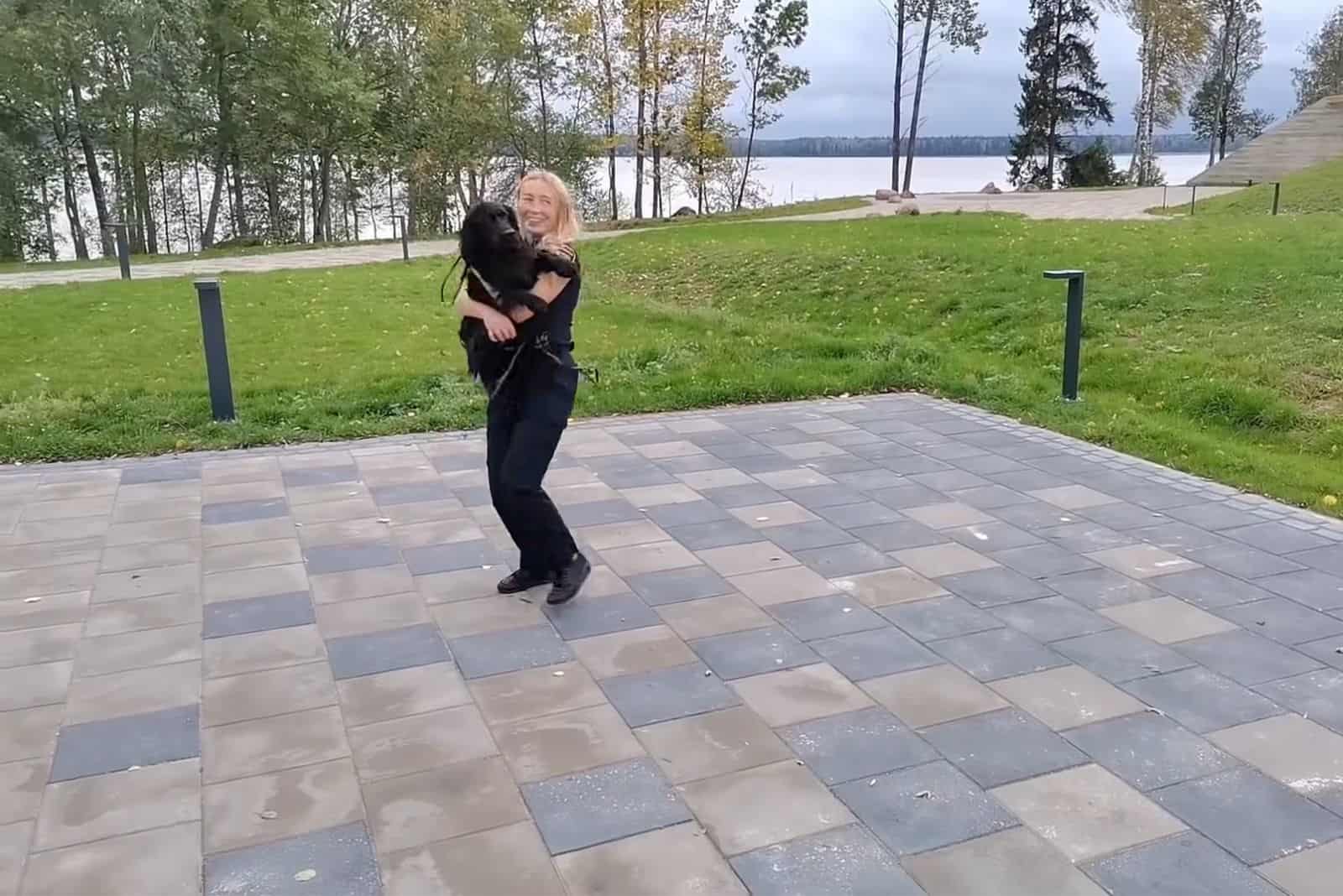 k9 police officer holding her dog in arms while dancing together