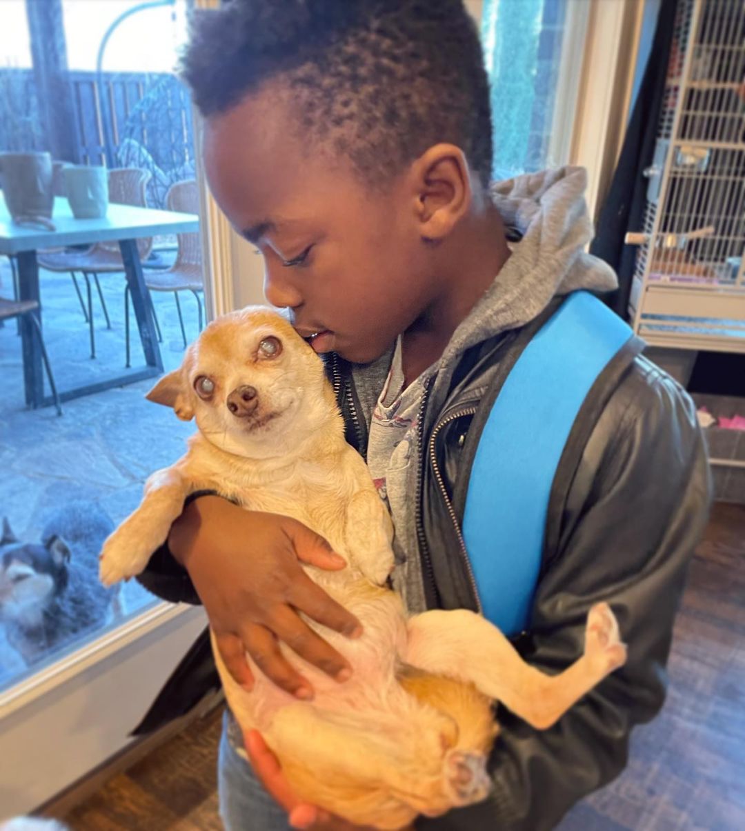 Kid kissing his blind dog