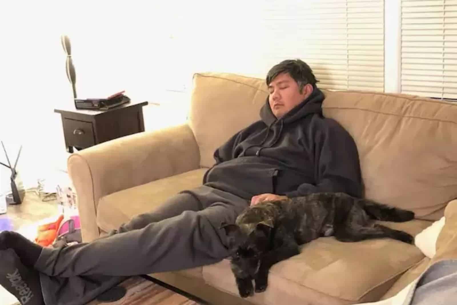 man and dog resting on the couch