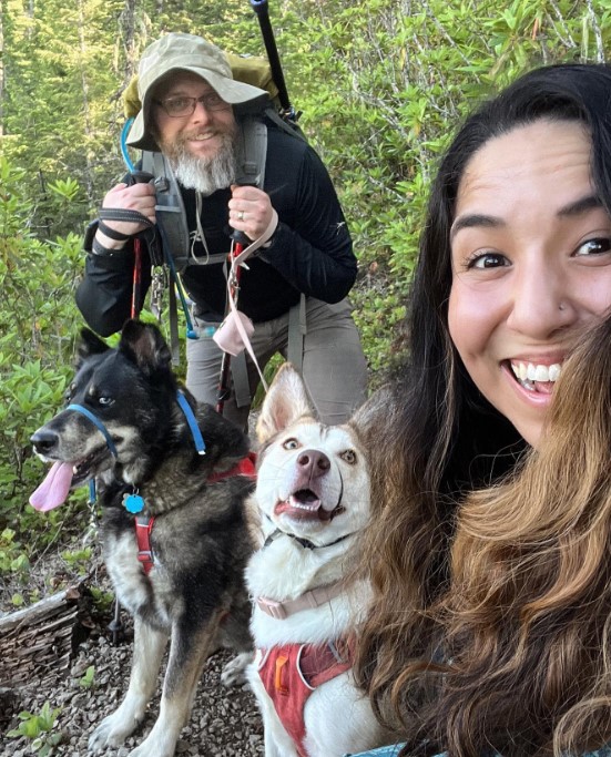 man and woman with dogs in the forest