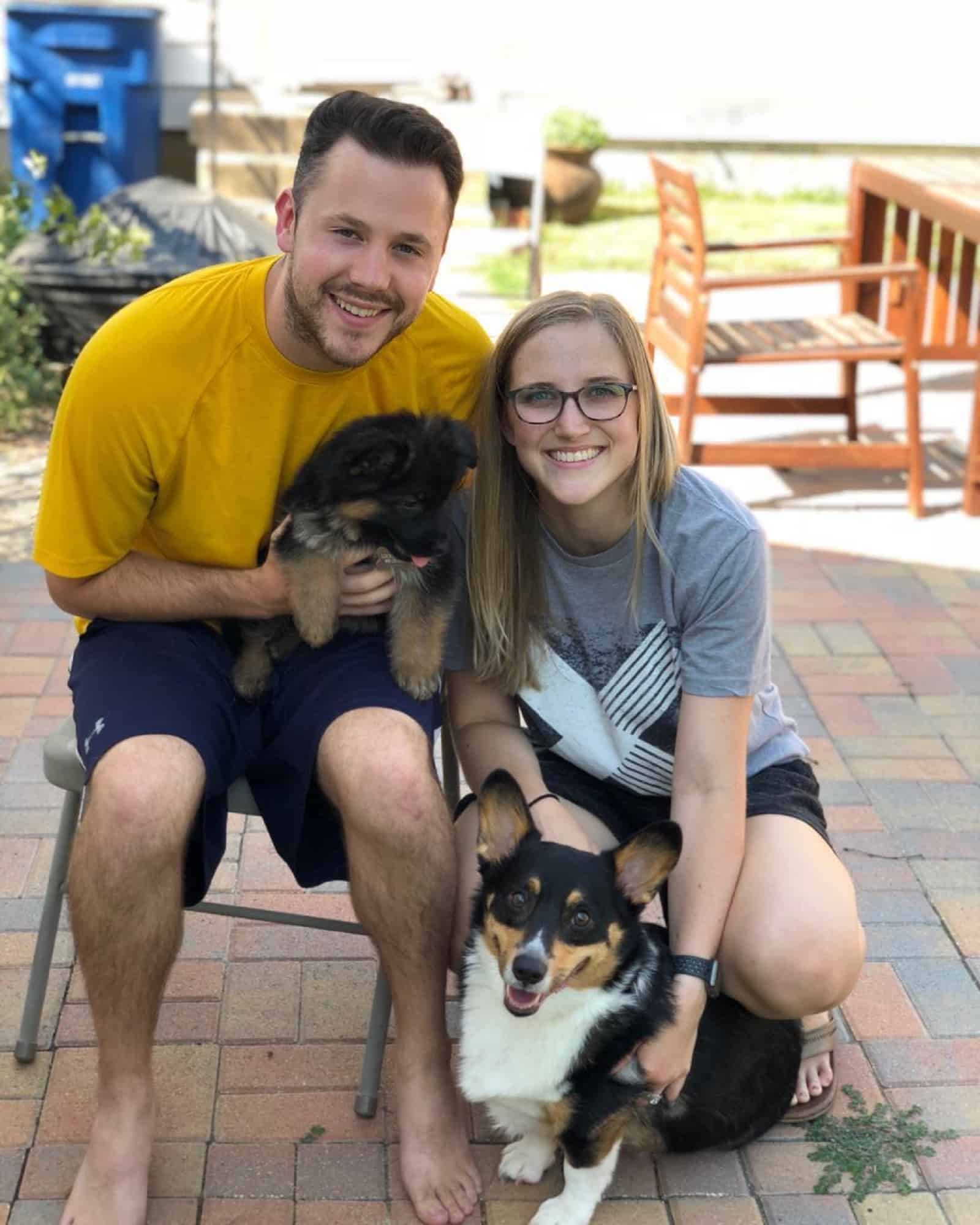 man and woman with their dogs posing for photography