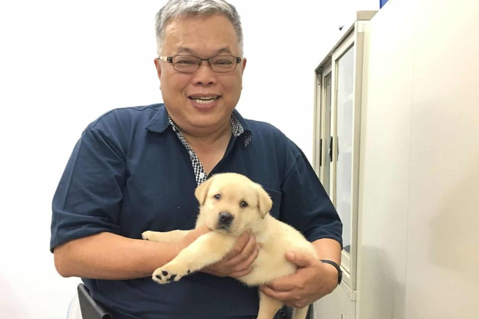 man holding a puppy in his arms