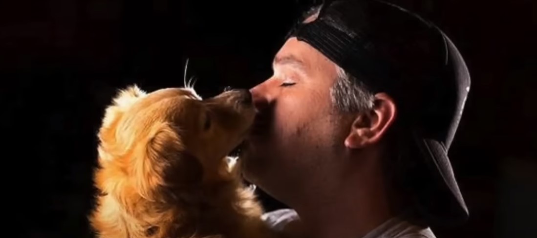 man kissing dog