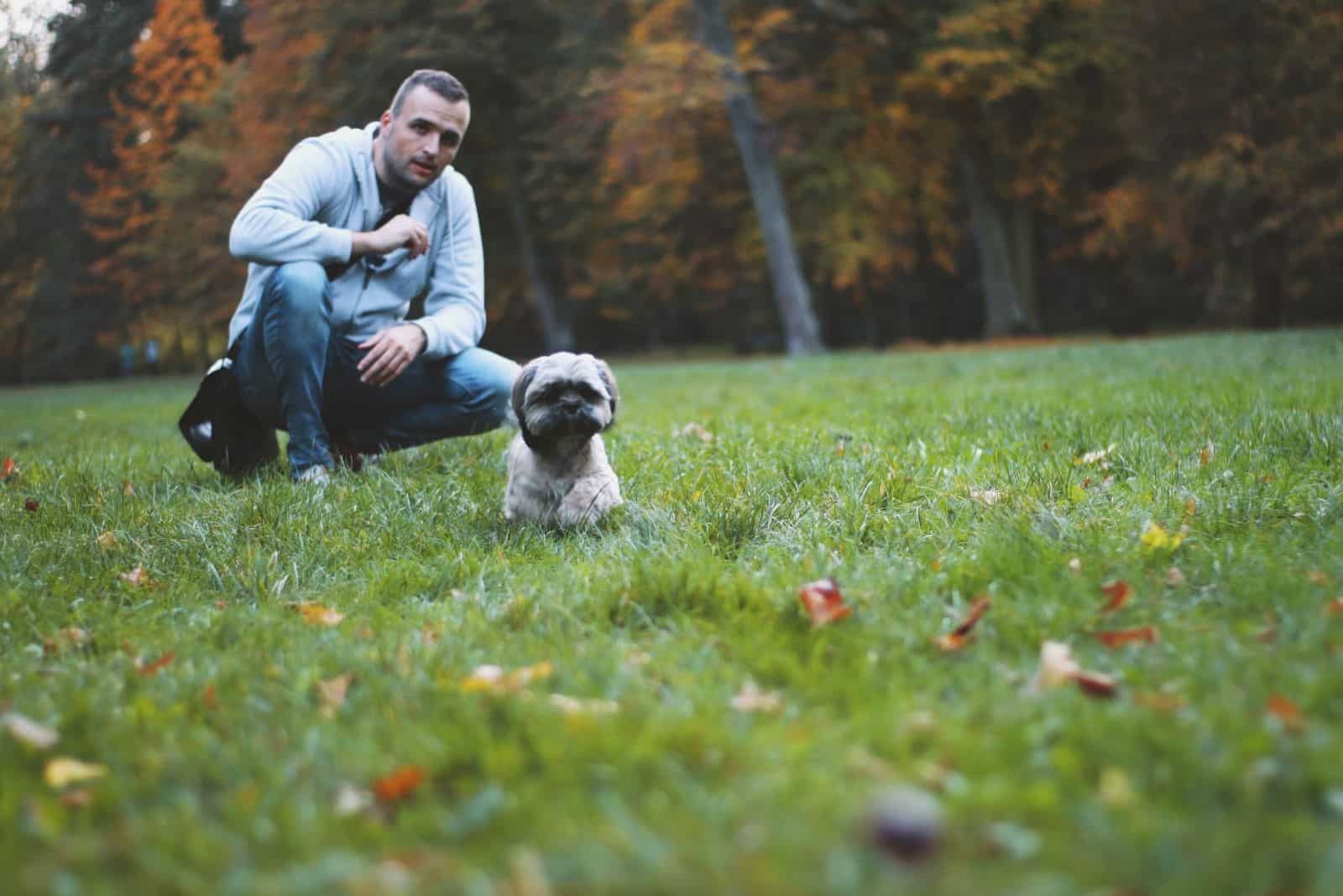 man looking at the puppy running in nature