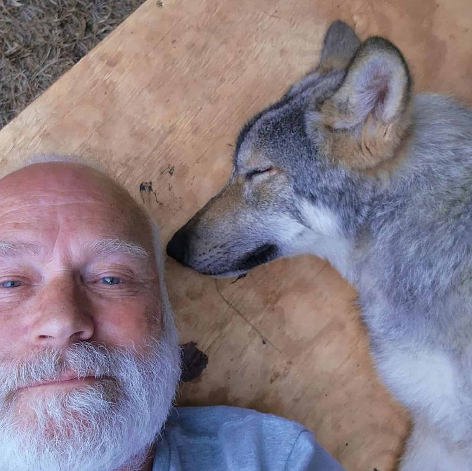 man lying beside his dog outdoors