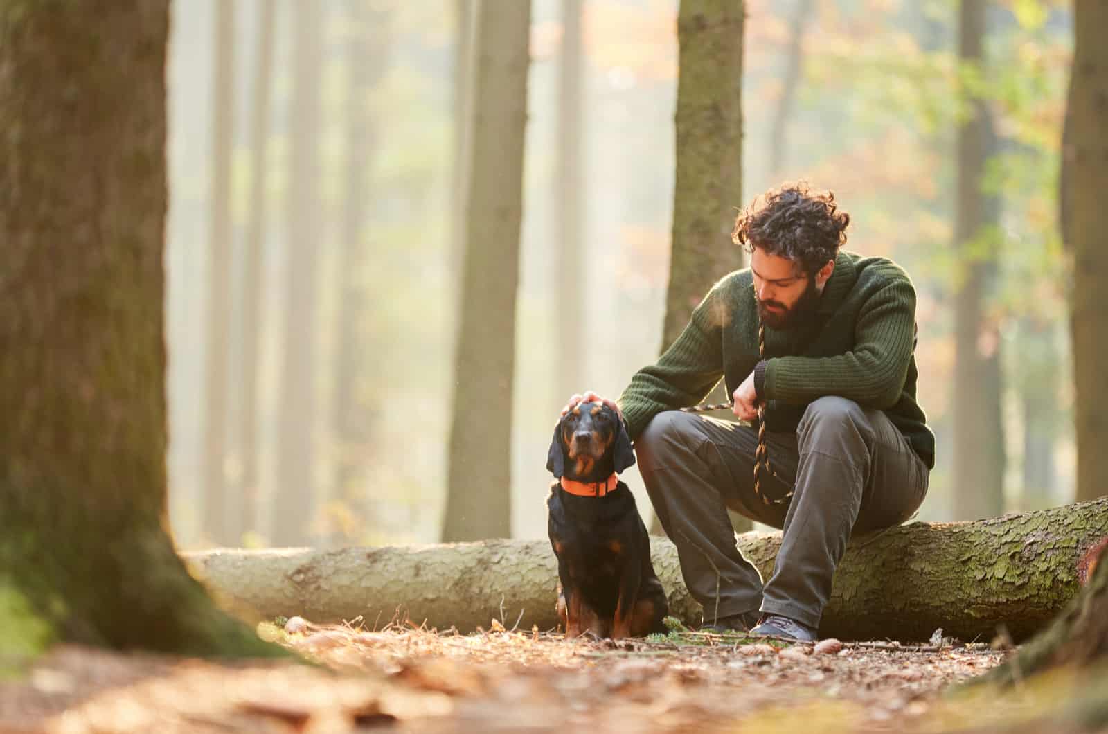 man petting his hunting dog