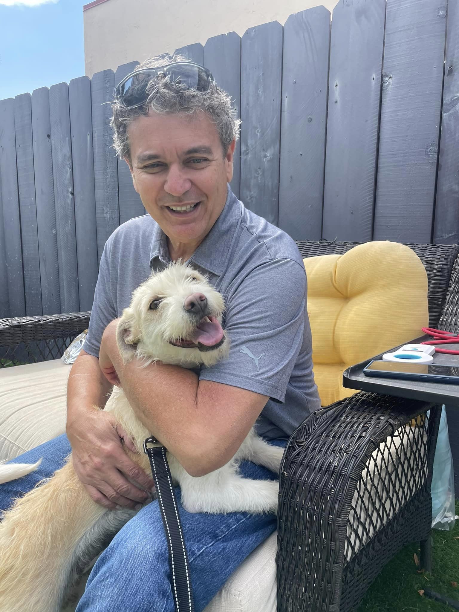 man sitting in a chair and hugging the dog