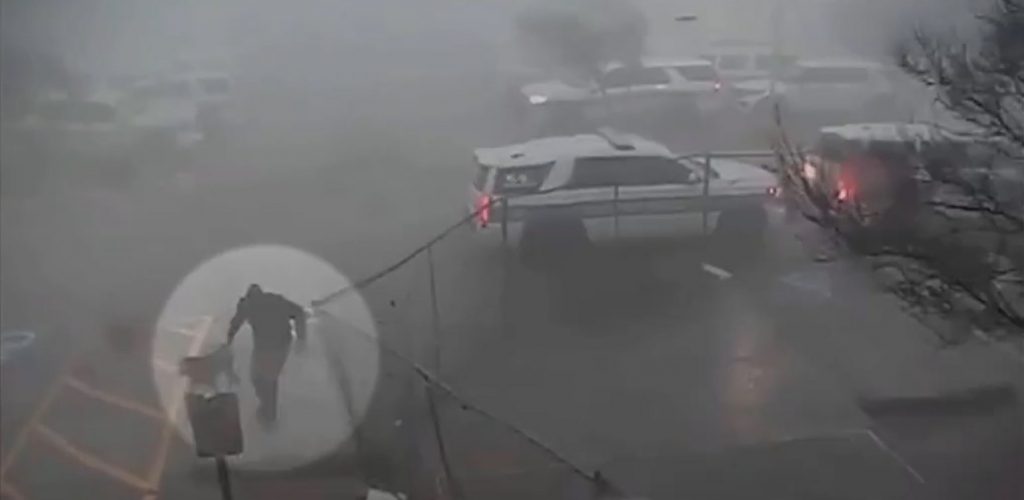 officer running with his K-9 partner through tornado