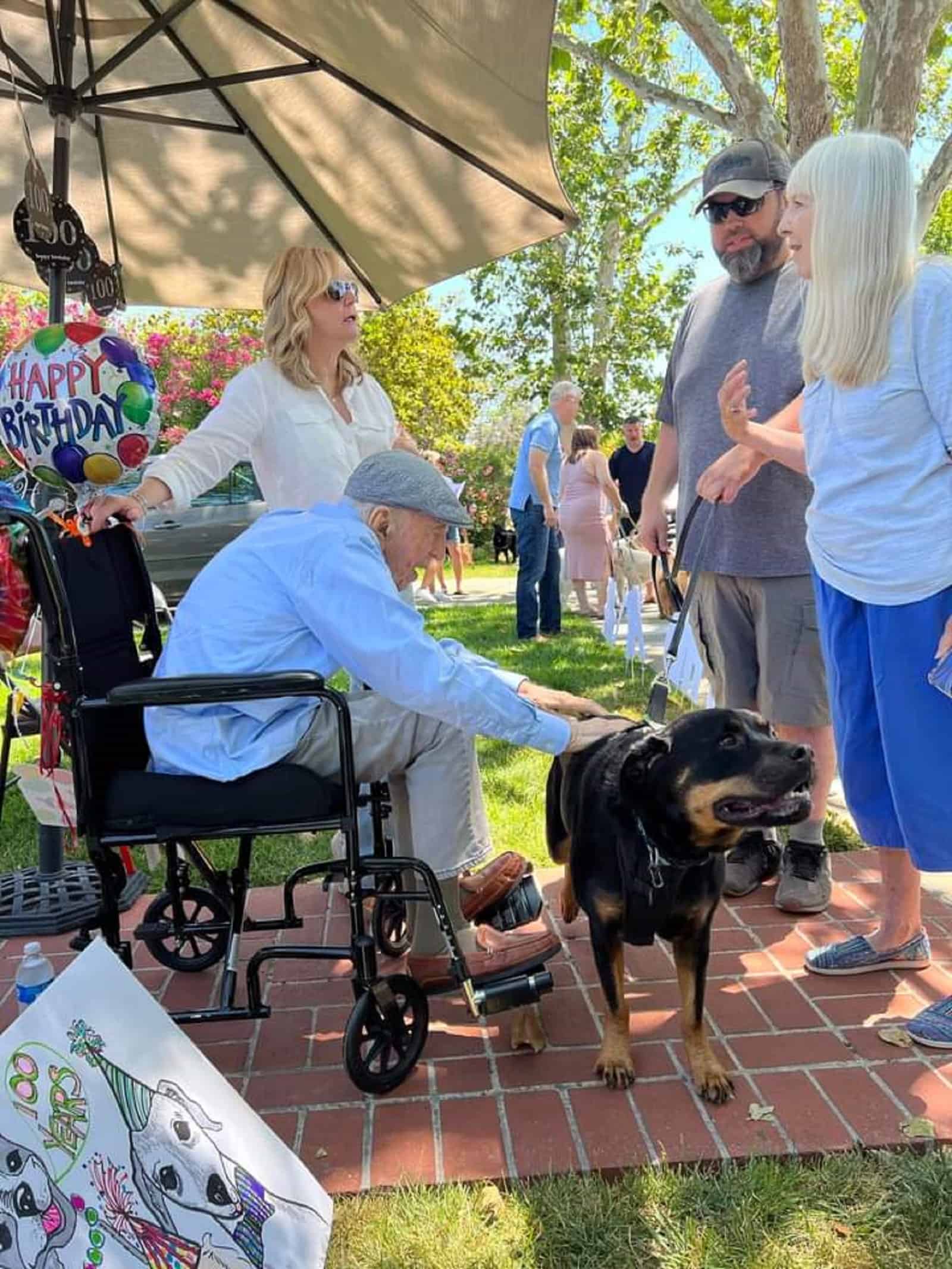 old man cuddling a dog on his 100th birthday celebration