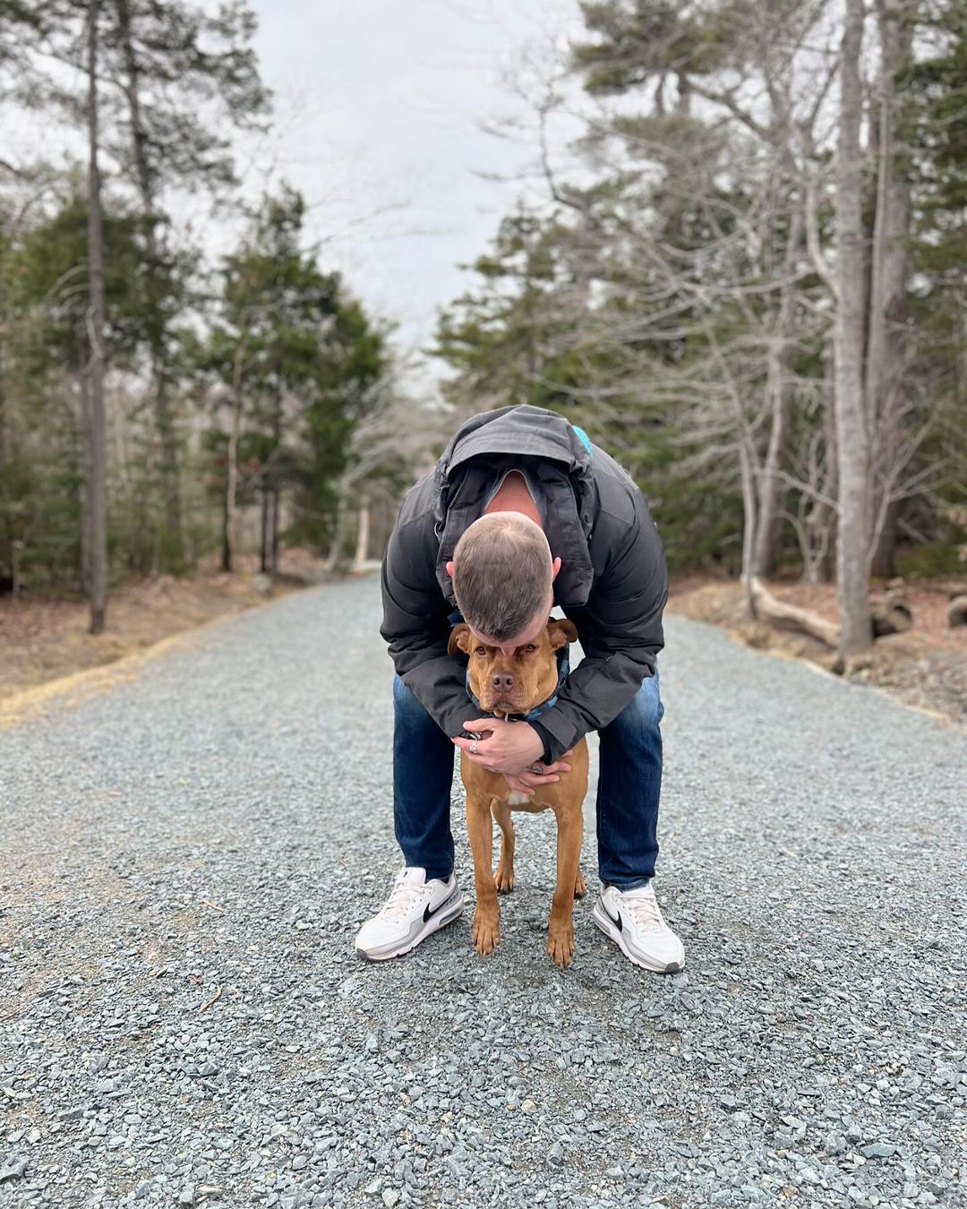 owner and dog on a road