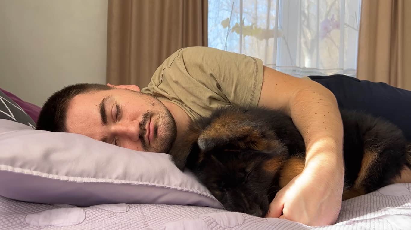 Owner hugging dog while sleeping